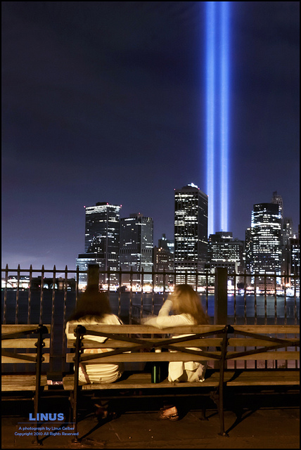 This year's Tribute in Light 9/11 memorial, taken from the Brooklyn Heights Promenade. Two women watch and talk in the foreground. 